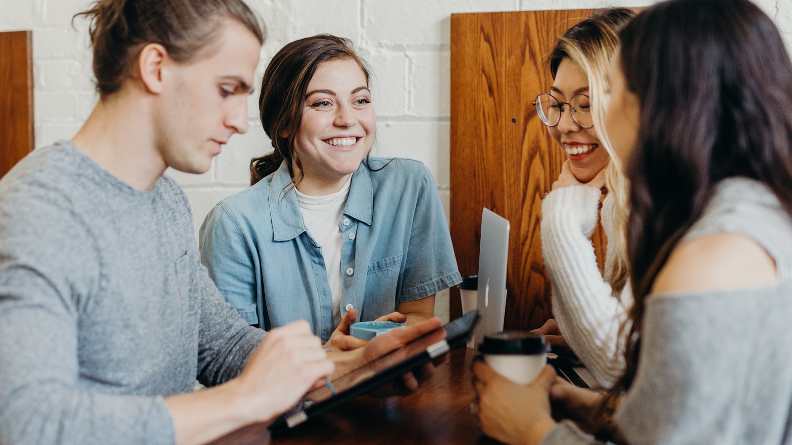 A diverse group of people having a conversation around a table — multilingual tenant communication.